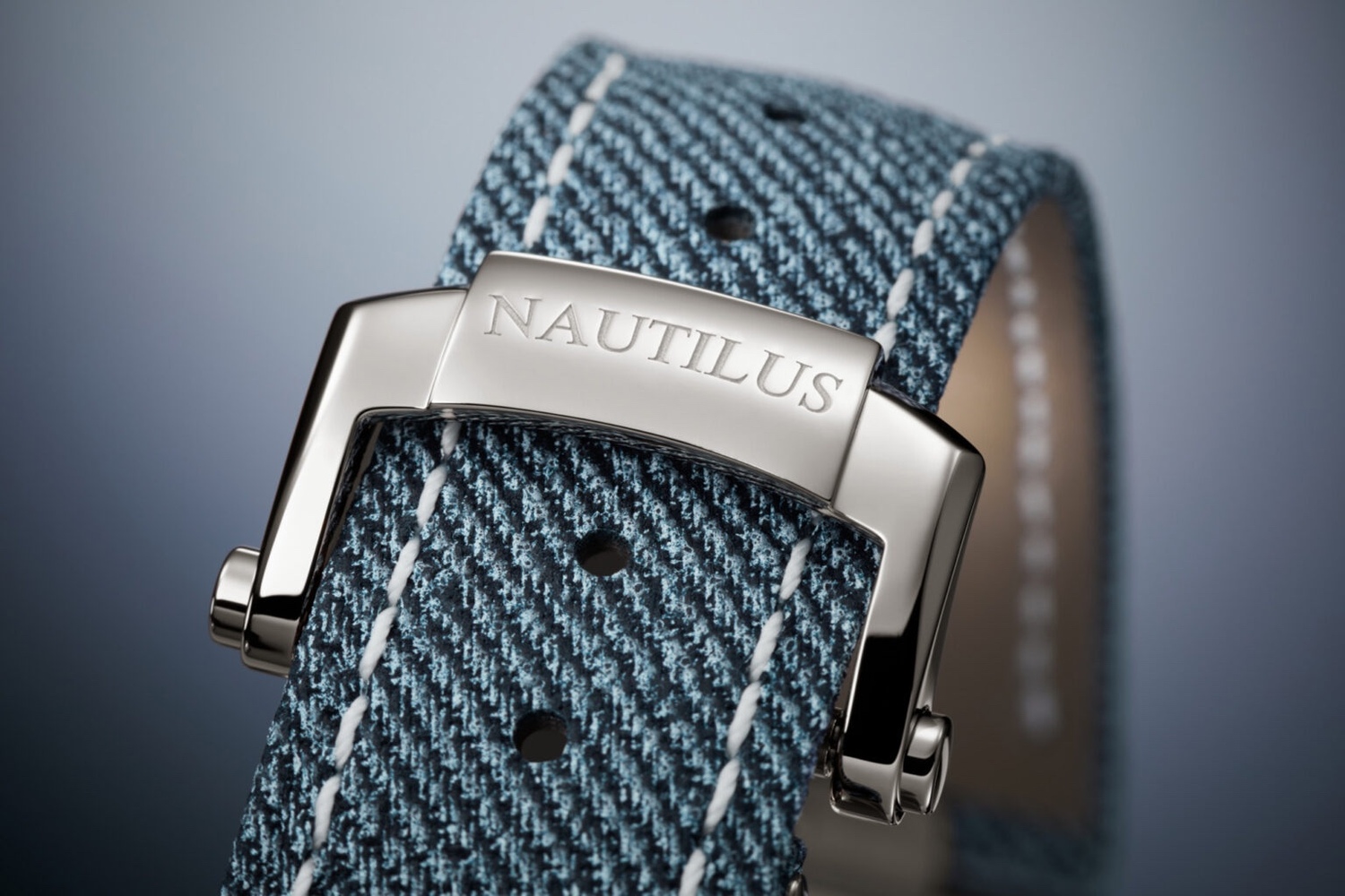 百达翡丽 Nautilus 参考号 5980-60G 中添加的新表带设计无疑是本次发布的亮点。这款小牛皮表带通过该系列经典的抛光矩形集成中心链节固定在表壳上，准确捕捉照片中牛仔布的纹理和颜色变化。