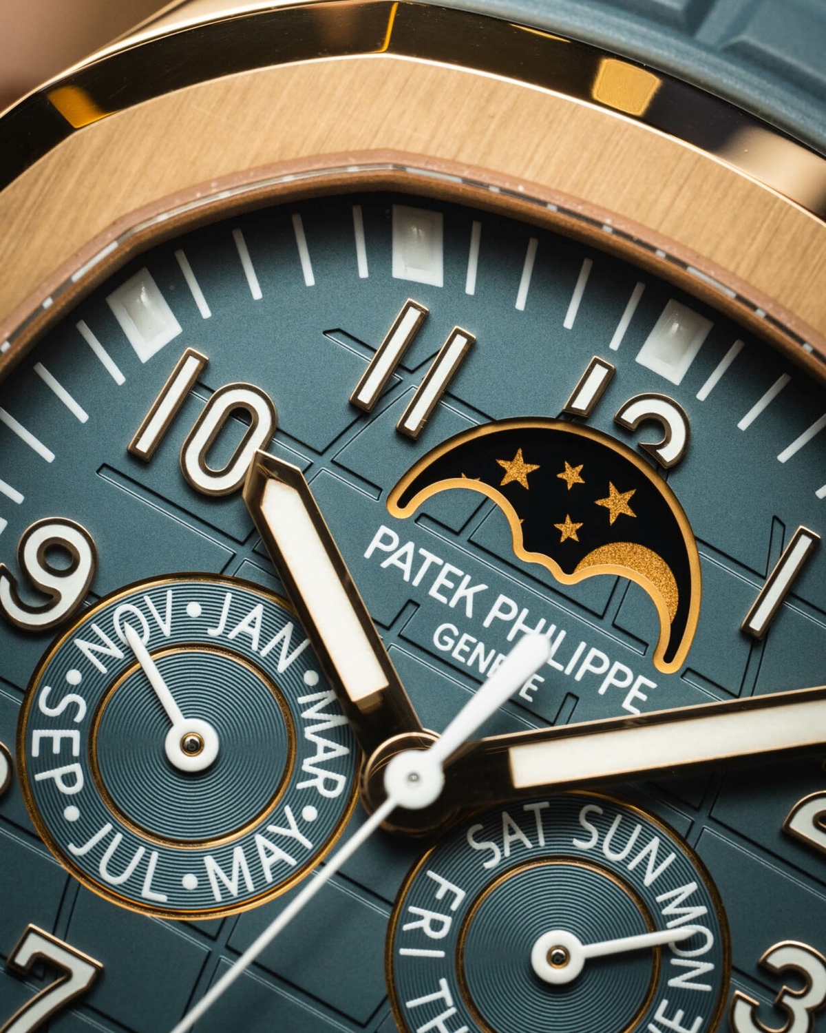 新款 Philippe Aquanaut Luce 年历 5261R-001 所配备的表盘呈现蓝灰色，表面压印有 Aquanaut 标志性的“手榴弹”图案。