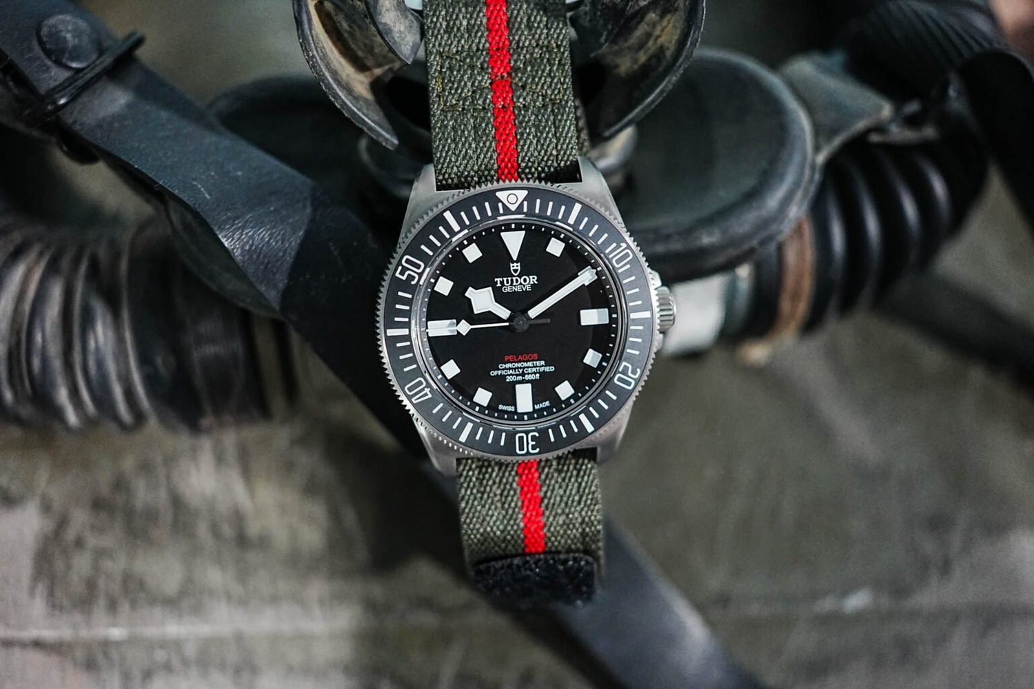 Pelagos FSD专业潜水腕表 型号25717，钛金属表壳，表径42毫米，厚12.75毫米，钛金属双向旋转外圈，配哑黑色陶质60分钟逆向刻度字圈，固定式表带杆，钛金属表冠，饰以浮雕帝舵表盾牌标志，哑黑色表面，红色PELAGOS表款字样，时、分、秒，帝舵表原厂MT5602型双向摆陀系统自动上链机械机芯，动力储备约70小时，瑞士官方天文台认证（COSC）天文台精密时计，蓝宝石水晶玻璃镜面，钢表壳底盖，防水200米（660呎），军绿色织纹表带，中央红色条纹，配备自黏式带扣，附送饰有织纹图案的黑色橡胶表带，配钛金属针扣。